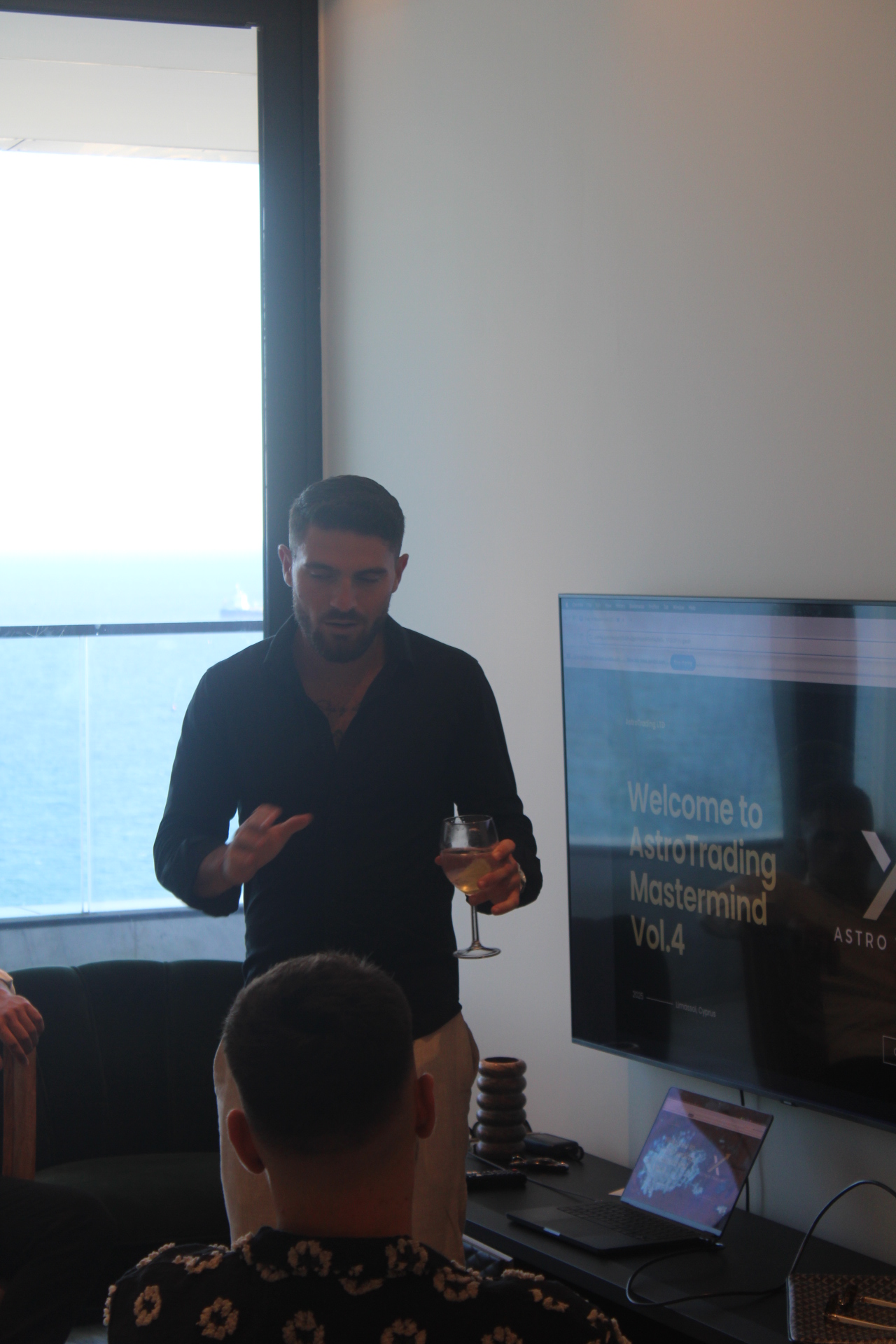 A silver toy rocket takes off, emitting white smoke, mounted on a white cube, in the foreground of a blurred office settin...